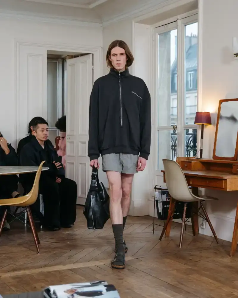 CAMIEL FORTGENS REWORKS DOMESTIC MATERIALS FOR FW26 Camiel Fortgens Fall/Winter 2026 collection shown in Paris apartment, featuring garments made from domestic materials like curtain pleats and sofa leather in earthy tones. (image 9 of 19)