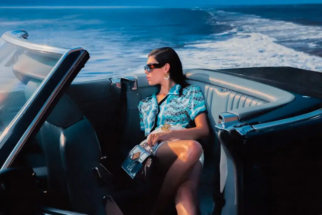 Casablanca Model relaxing on Tenerife beach at sunset wearing Casablanca Beach Club 2025 gradient monogram linen shirt and trousers (image 2 of 5)