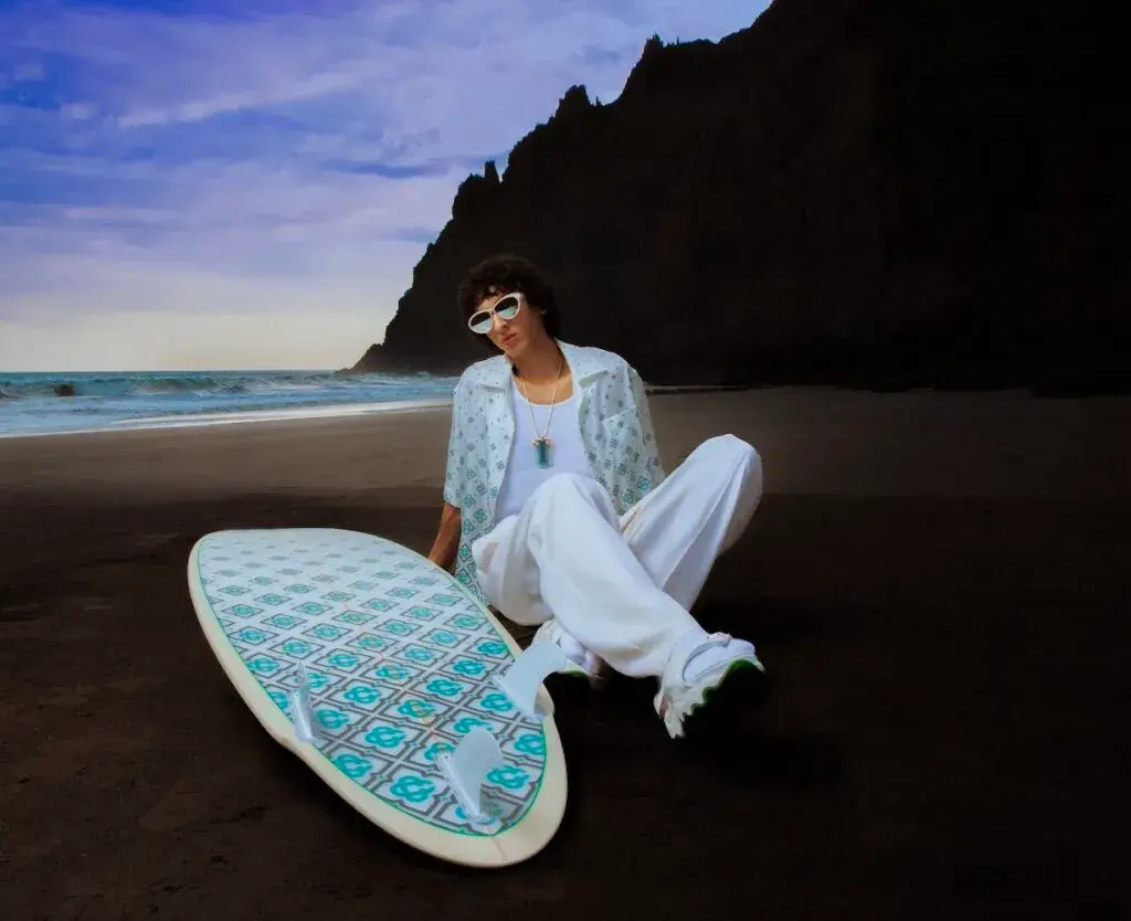 Casablanca Model relaxing on Tenerife beach at sunset wearing Casablanca Beach Club 2025 gradient monogram linen shirt and trousers