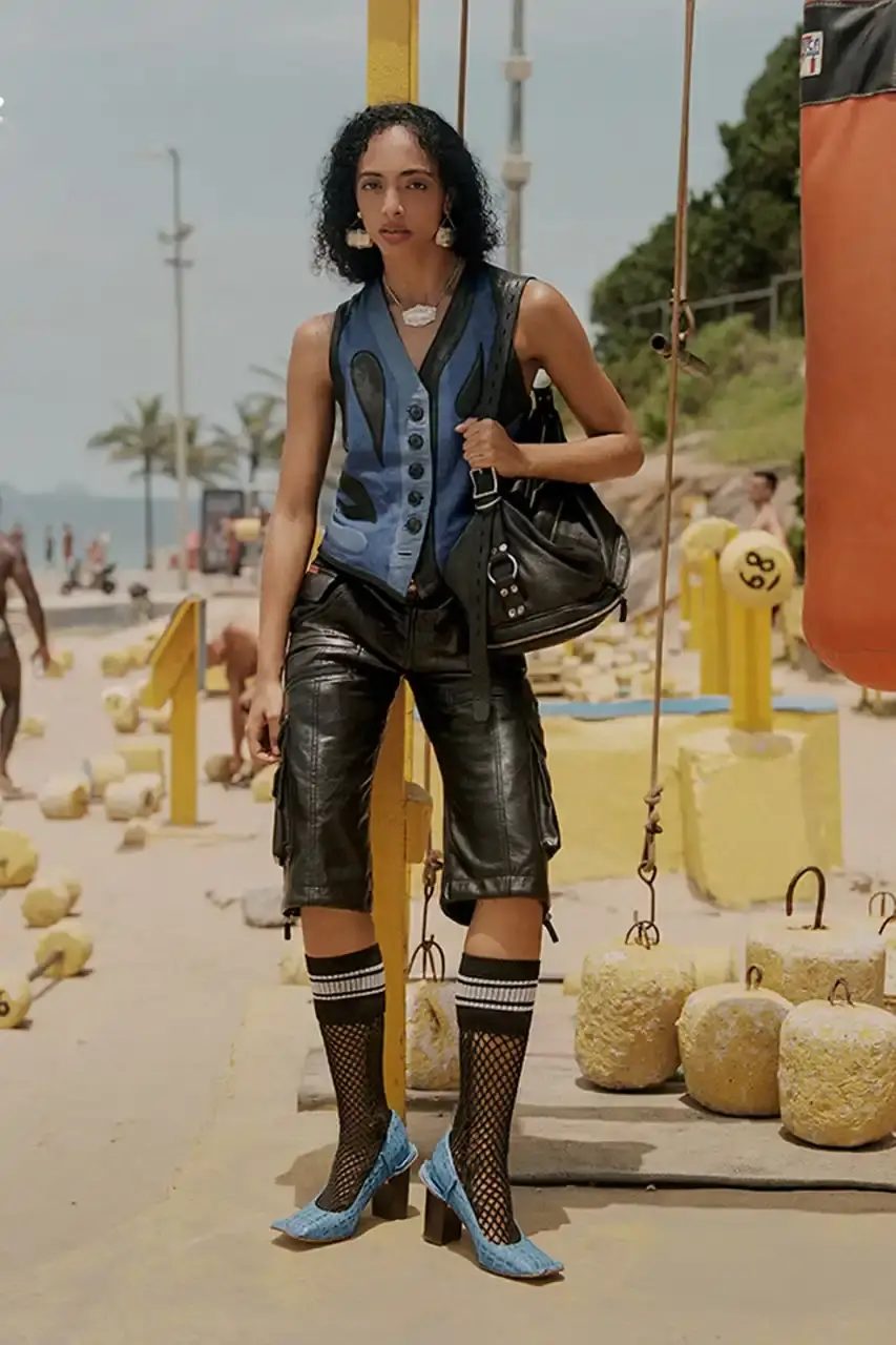MARTINE ROSE RESHAPES CLARKS HERITAGE IN SS25 COLLECTION An image description for screen readers that highlights the key visual elements of the Clarks x Martine Rose SS25 campaign, focusing on the three shoe styles (Derby, Torview, and Heel) photographed on local beachgoers, showcasing the unique design details, textures, and color palette of the collection.