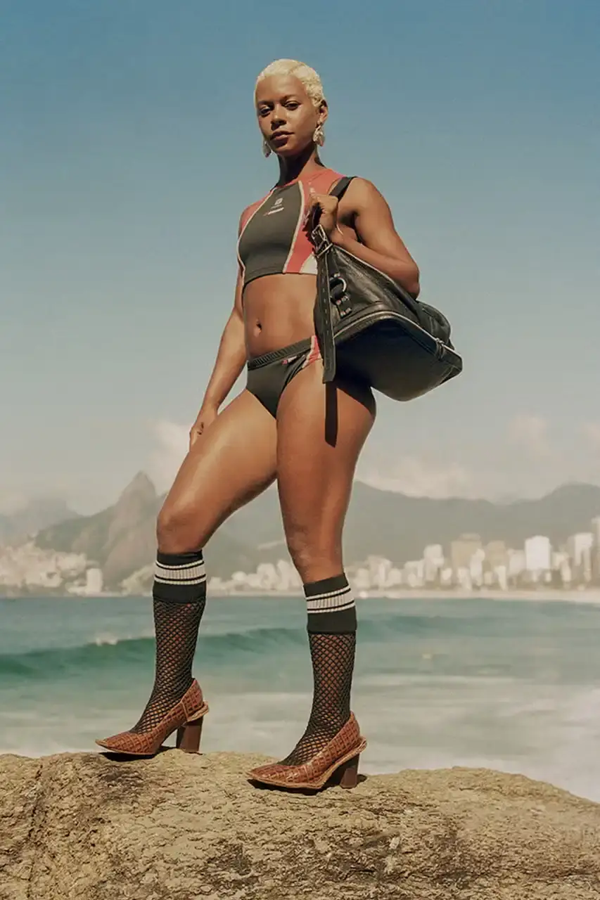 MARTINE ROSE RESHAPES CLARKS HERITAGE IN SS25 COLLECTION An image description for screen readers that highlights the key visual elements of the Clarks x Martine Rose SS25 campaign, focusing on the three shoe styles (Derby, Torview, and Heel) photographed on local beachgoers, showcasing the unique design details, textures, and color palette of the collection. (image 2 of 6)