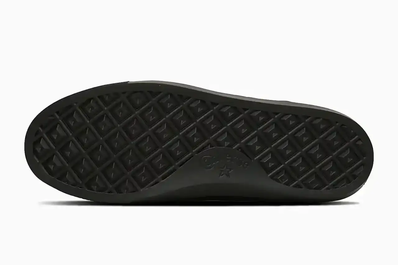 Converse Converse All-Star Coupe GB Loafer shown from side angle, featuring minimalist leather construction, tasseled midfoot strap with embossed star details, and classic Converse sole. Available in black and off-white colorways. (image 4 of 8)