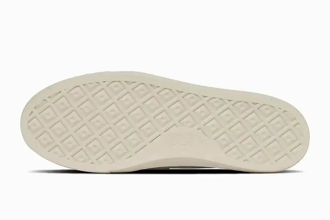 Converse Converse All-Star Coupe GB Loafer shown from side angle, featuring minimalist leather construction, tasseled midfoot strap with embossed star details, and classic Converse sole. Available in black and off-white colorways. (image 5 of 8)