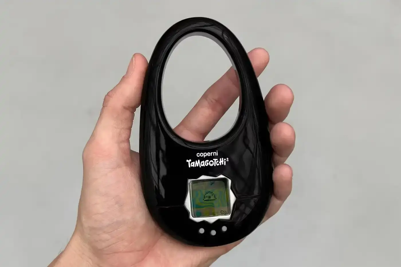 Coperni Small handbag in the shape of Coperni's signature Swipe design, modified to include a Tamagotchi digital pet display, available in navy, black and silver. (image 2 of 4)