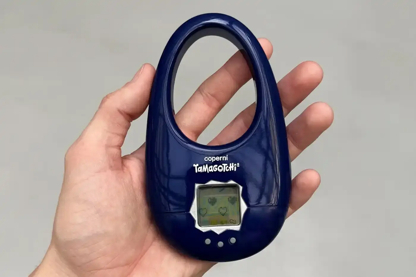 Coperni Small handbag in the shape of Coperni's signature Swipe design, modified to include a Tamagotchi digital pet display, available in navy, black and silver. (image 3 of 4)