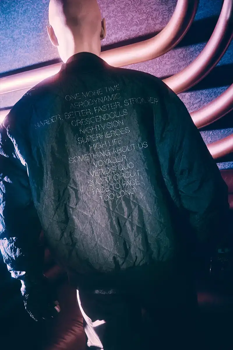 DAFT PUNK TEAMS UP WITH PLEASURES FOR NEW CAPSULE image about fashion collaboration between electronic music duo Daft Punk and streetwear brand PLEASURES. Features clothing and accessories incorporating the musicians' robot helmet imagery, album artwork, and references to their music videos and films. Collection includes hoodies, jackets, jeans, and accessories available July 16, 2025. (image 2 of 28)