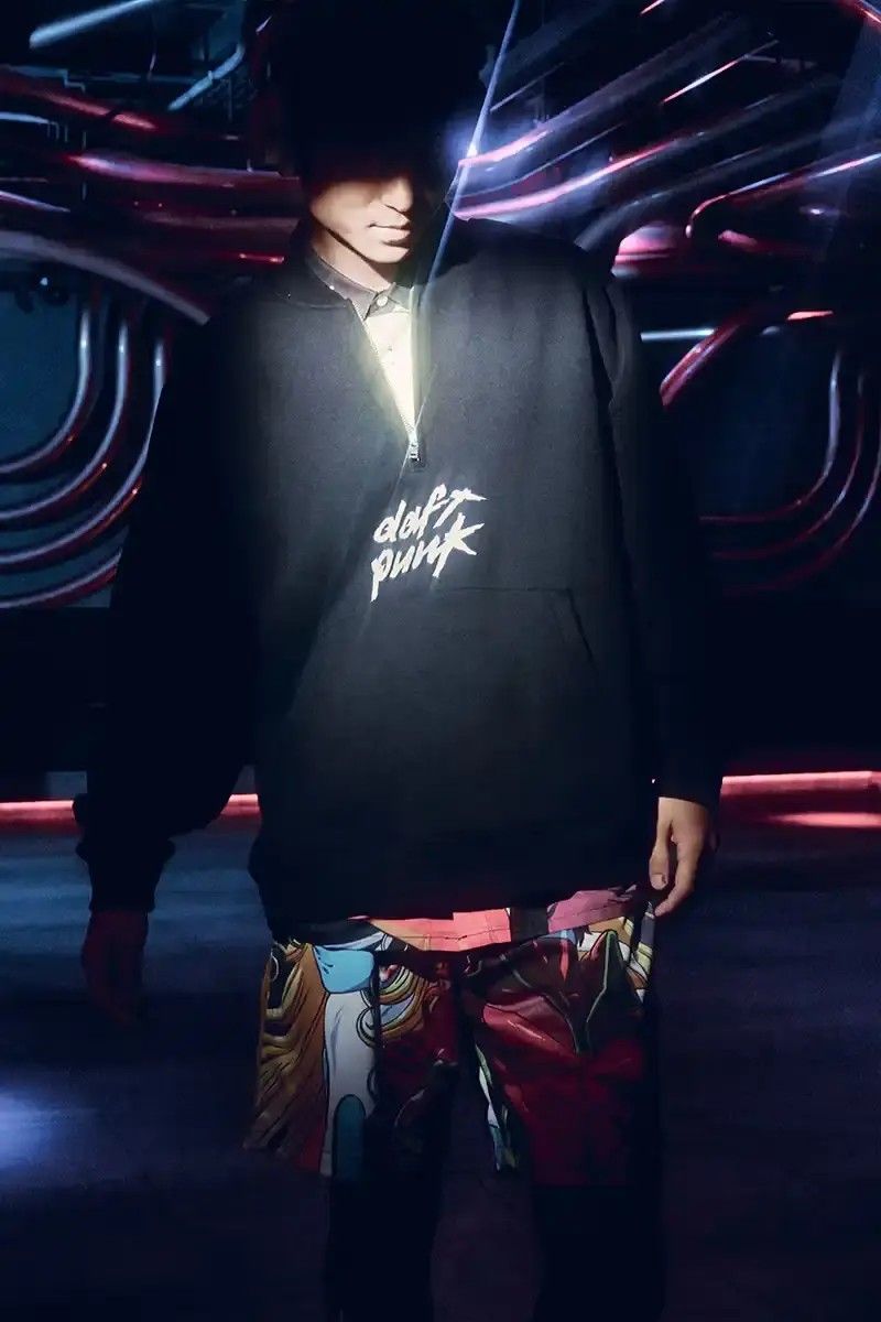 DAFT PUNK TEAMS UP WITH PLEASURES FOR NEW CAPSULE image about fashion collaboration between electronic music duo Daft Punk and streetwear brand PLEASURES. Features clothing and accessories incorporating the musicians' robot helmet imagery, album artwork, and references to their music videos and films. Collection includes hoodies, jackets, jeans, and accessories available July 16, 2025. (image 9 of 28)
