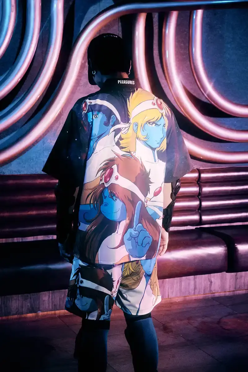 DAFT PUNK TEAMS UP WITH PLEASURES FOR NEW CAPSULE image about fashion collaboration between electronic music duo Daft Punk and streetwear brand PLEASURES. Features clothing and accessories incorporating the musicians' robot helmet imagery, album artwork, and references to their music videos and films. Collection includes hoodies, jackets, jeans, and accessories available July 16, 2025. (image 24 of 28)