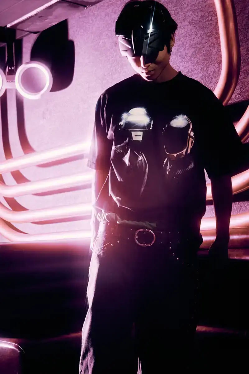DAFT PUNK TEAMS UP WITH PLEASURES FOR NEW CAPSULE image about fashion collaboration between electronic music duo Daft Punk and streetwear brand PLEASURES. Features clothing and accessories incorporating the musicians' robot helmet imagery, album artwork, and references to their music videos and films. Collection includes hoodies, jackets, jeans, and accessories available July 16, 2025. (image 12 of 28)
