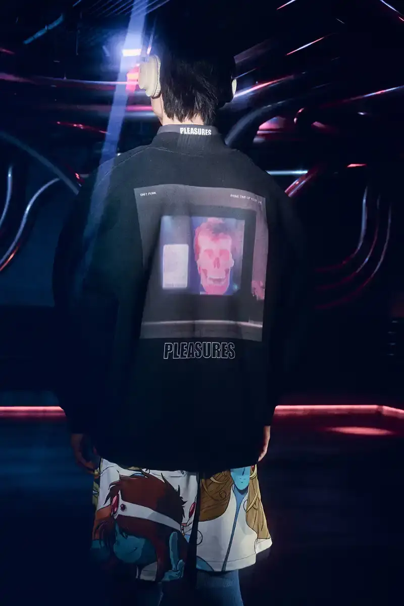DAFT PUNK TEAMS UP WITH PLEASURES FOR NEW CAPSULE image about fashion collaboration between electronic music duo Daft Punk and streetwear brand PLEASURES. Features clothing and accessories incorporating the musicians' robot helmet imagery, album artwork, and references to their music videos and films. Collection includes hoodies, jackets, jeans, and accessories available July 16, 2025. (image 8 of 28)