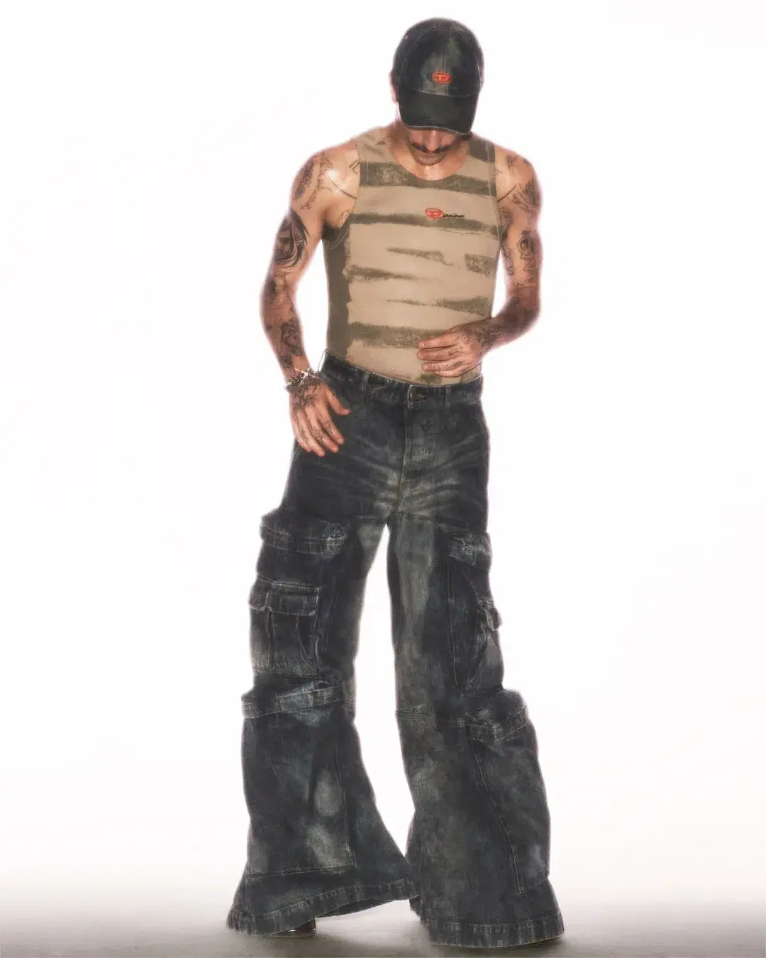 Diesel The article discusses a new capsule collection collaboration between the fashion brand Diesel and Damiano David, the lead singer of the band Måneskin. The collection combines Diesel's edgy, gender-fluid aesthetic with elements inspired by Damiano's personal style and tattoos. Key pieces include oversized tops, drawstring pants, and denim items with distinctive treatments. The capsule is now available for purchase on Diesel's website. (image 3 of 10)