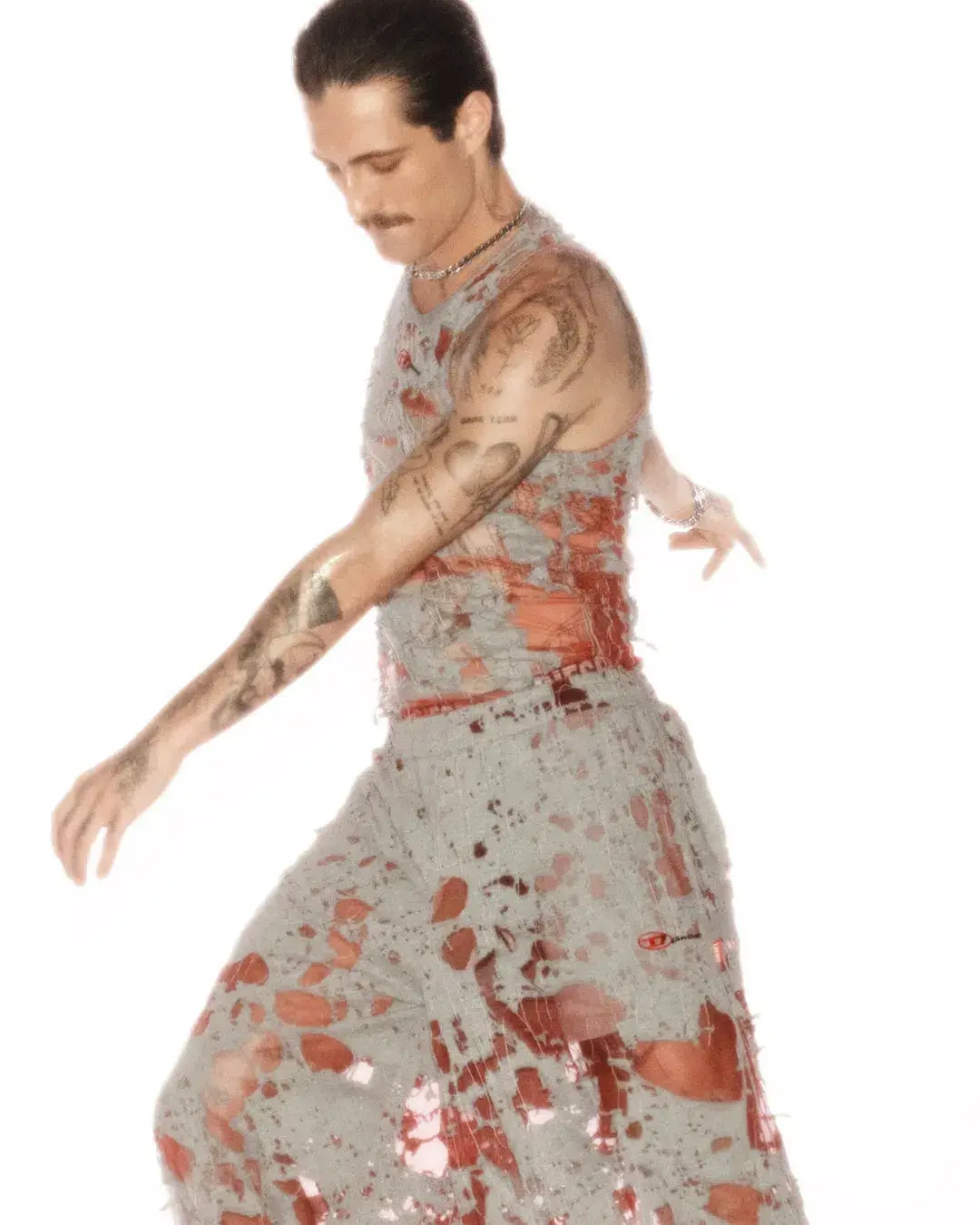 Diesel The article discusses a new capsule collection collaboration between the fashion brand Diesel and Damiano David, the lead singer of the band Måneskin. The collection combines Diesel's edgy, gender-fluid aesthetic with elements inspired by Damiano's personal style and tattoos. Key pieces include oversized tops, drawstring pants, and denim items with distinctive treatments. The capsule is now available for purchase on Diesel's website. (image 7 of 10)