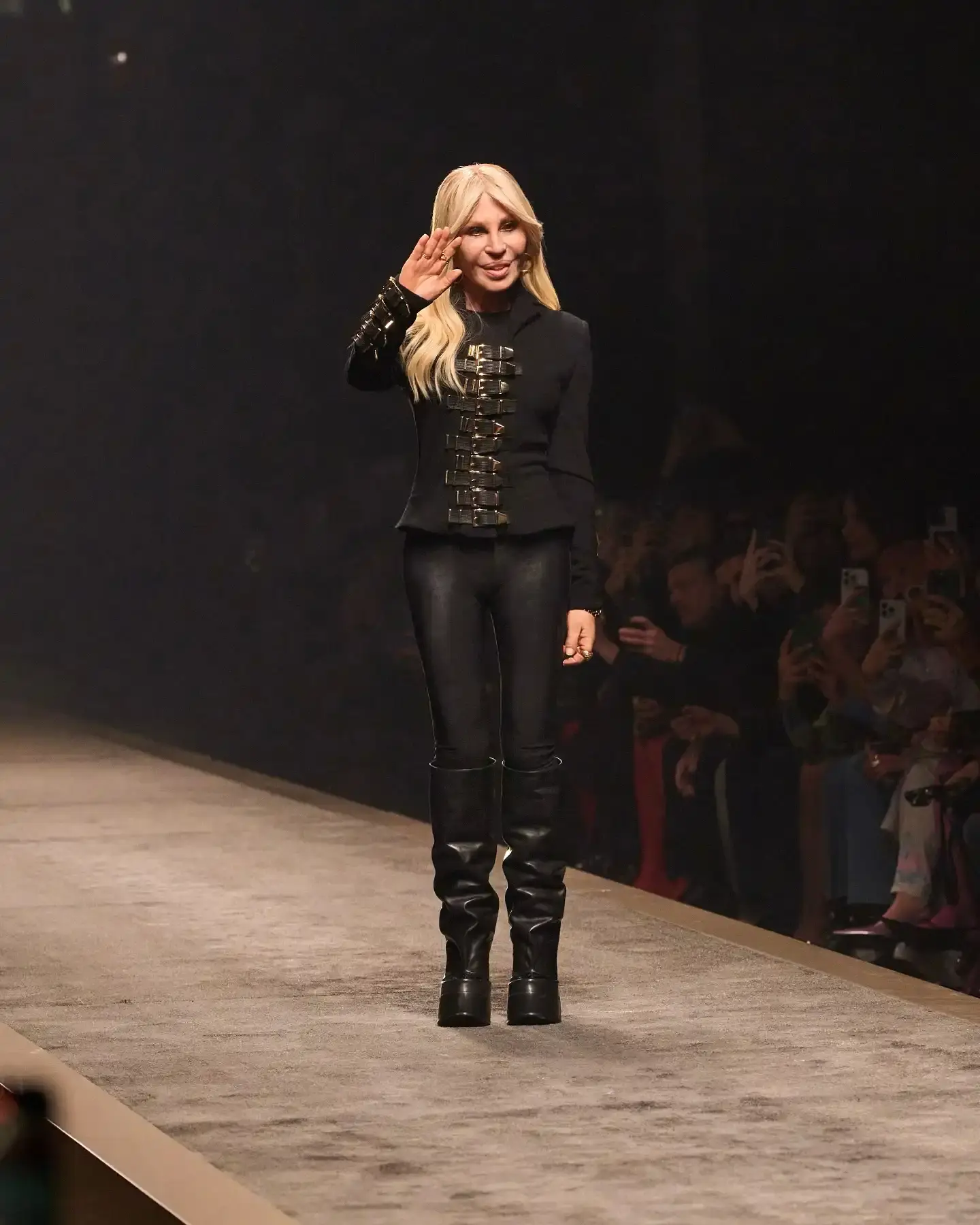 Donatella Versace, blonde-haired fashion icon in elegant black attire, pictured at Versace headquarters announcing her transition from creative director to brand ambassador after nearly three decades with the fashion house.