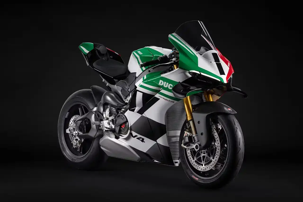Ducati A side profile view of the Ducati Panigale V4 Tricolore motorcycle, showcasing its sleek racing design with asymmetrical Italian flag-inspired color scheme. The bike features carbon fiber rims, a racing-inspired silhouette, and a distinctive checkered flag motif, highlighting its special edition status and high-performance engineering. (image 3 of 7)