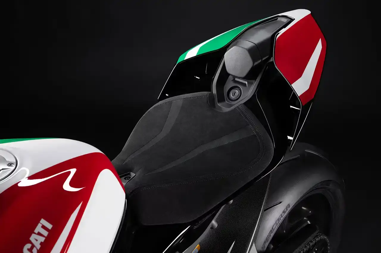 Ducati A side profile view of the Ducati Panigale V4 Tricolore motorcycle, showcasing its sleek racing design with asymmetrical Italian flag-inspired color scheme. The bike features carbon fiber rims, a racing-inspired silhouette, and a distinctive checkered flag motif, highlighting its special edition status and high-performance engineering. (image 7 of 7)