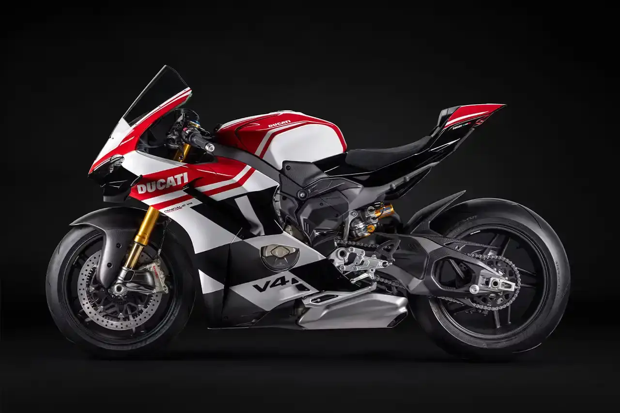 Ducati A side profile view of the Ducati Panigale V4 Tricolore motorcycle, showcasing its sleek racing design with asymmetrical Italian flag-inspired color scheme. The bike features carbon fiber rims, a racing-inspired silhouette, and a distinctive checkered flag motif, highlighting its special edition status and high-performance engineering. (image 6 of 7)