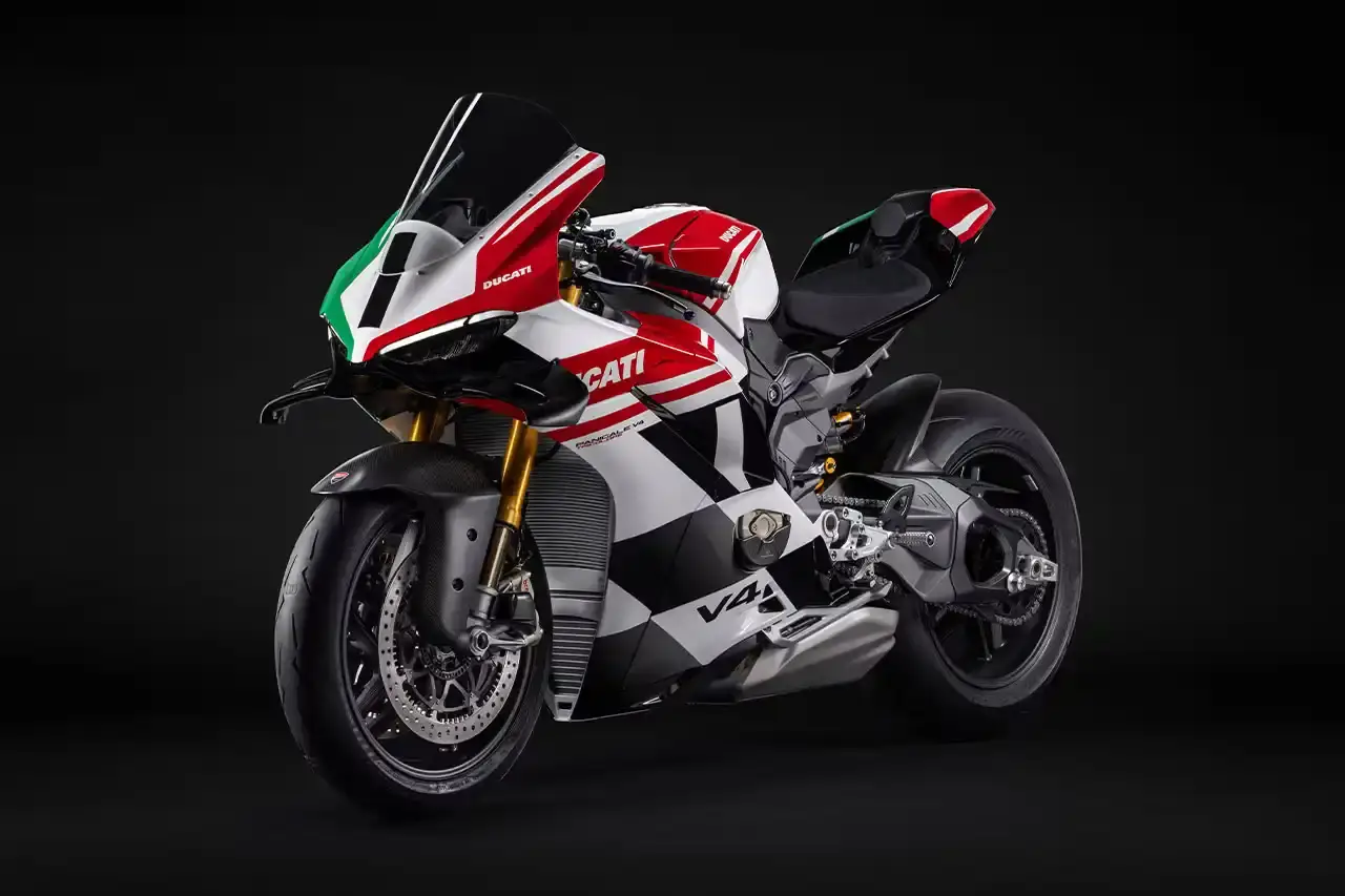 Ducati A side profile view of the Ducati Panigale V4 Tricolore motorcycle, showcasing its sleek racing design with asymmetrical Italian flag-inspired color scheme. The bike features carbon fiber rims, a racing-inspired silhouette, and a distinctive checkered flag motif, highlighting its special edition status and high-performance engineering. (image 2 of 7)