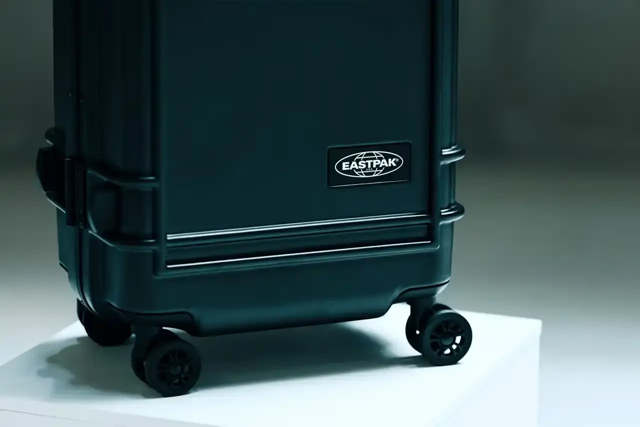 Eastpak Resist'r Case hard-shell luggage in three sizes - small, medium, and large - displayed in red, gray, and black colors. The suitcases feature a sleek polycarbonate exterior with aluminum frame, quiet wheels, and TSA-approved locks. Eastpak logo visible on the front
