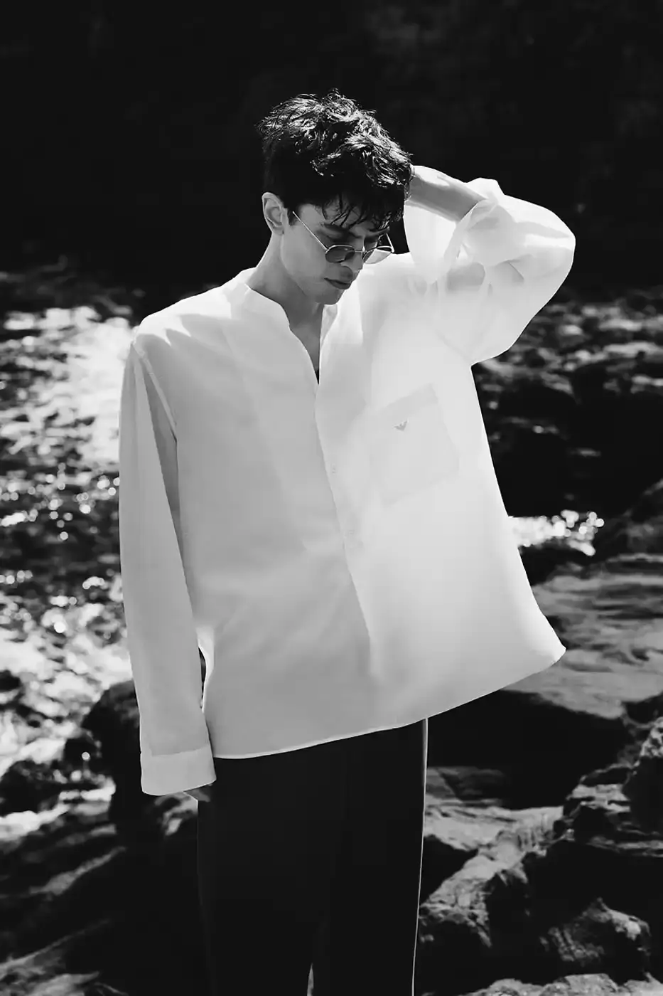 EMPORIO ARMANI AND OUR LEGACY: A SECOND CHAPTER IN DESIGN DIALOGUE image of second collaboration between Emporio Armani and Our Legacy Work Shop, detailing the expanded capsule collection that includes both menswear and womenswear. The collection features designs reimagined from Armani archives with East Asian influences, using both classic and recreated vintage fabrics. The article describes the campaign photographed by Alasdair McLellan on Pantelleria island, and provides information about the May 16 launch date and various retail locations where the collection will be available. (image 7 of 7)