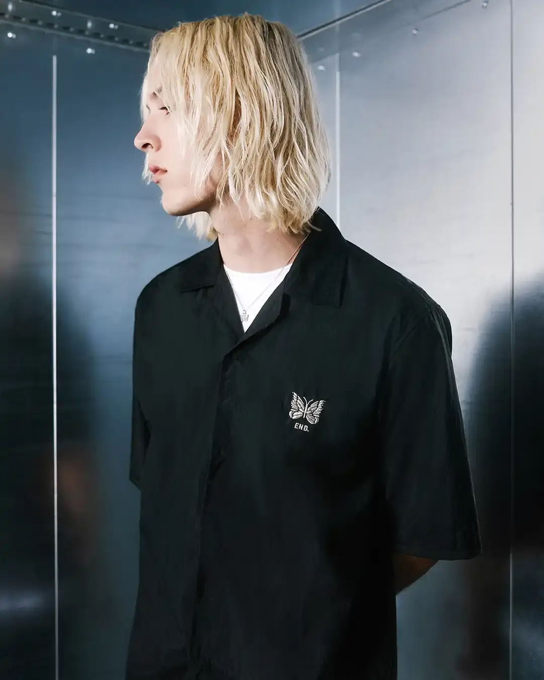 END. AND NEEDLES LAUNCH NYLON COLLECTION image about British retailer END.'s collaboration with Japanese streetwear brand Needles for their 20th anniversary. The partnership produced a five-piece collection made from crinkled nylon, including track pants, crew neck shirt, cabana shirt, sports jacket, and workers cap. All items feature platinum silver details and co-branded logos. The collection launched June 23rd, 2025, available online and in END. stores across the UK and Milan. (image 5 of 7)