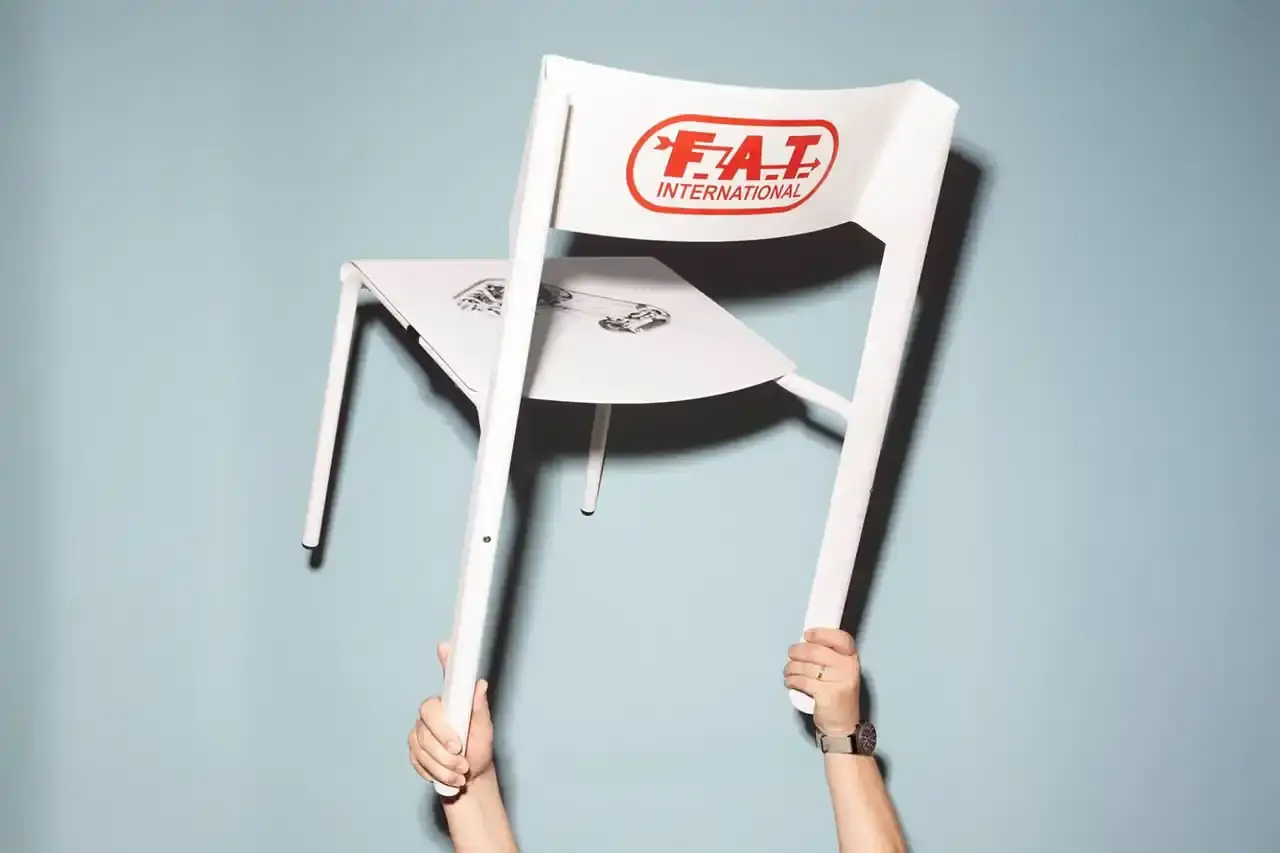 FAT International Limited-edition aluminum chair with racing-inspired design, featuring sleek metal frame and Porsche 959 graphic detail. Created by Marco Dessi for FAT International.
