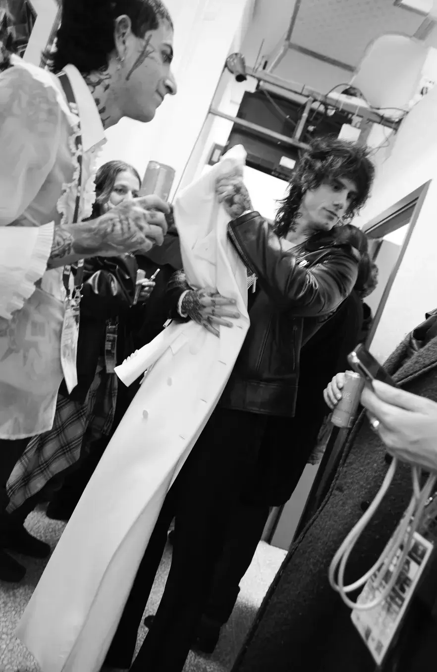 CREATIVITY IN MOTION WITH STYLIST FRANCESCO MAUTONE Stylist Francesco Mautone carrying an Eastpak bag while walking through a modern hotel lobby, representing creativity in motion. Photography by Simone Paccini (image 5 of 6)