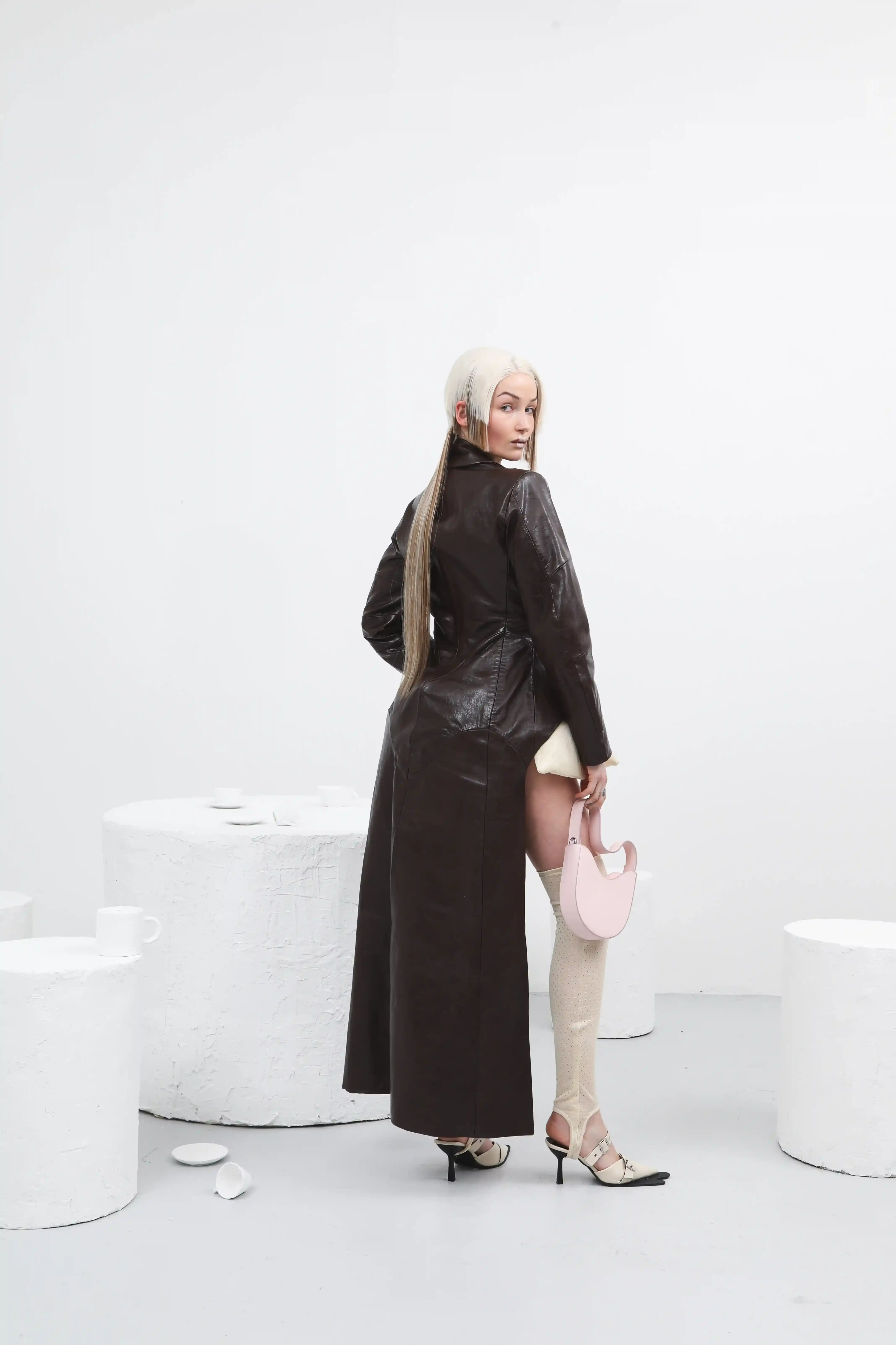 Antonio Giancaspro BERGIE's FW25 collection by Giorgiandreazza featuring sustainable Coffee Leather accessories made from recycled coffee grounds. The image shows the contrast between warm, traditional craftsmanship and innovative material technology in a luxury fashion context. (image 11 of 13)