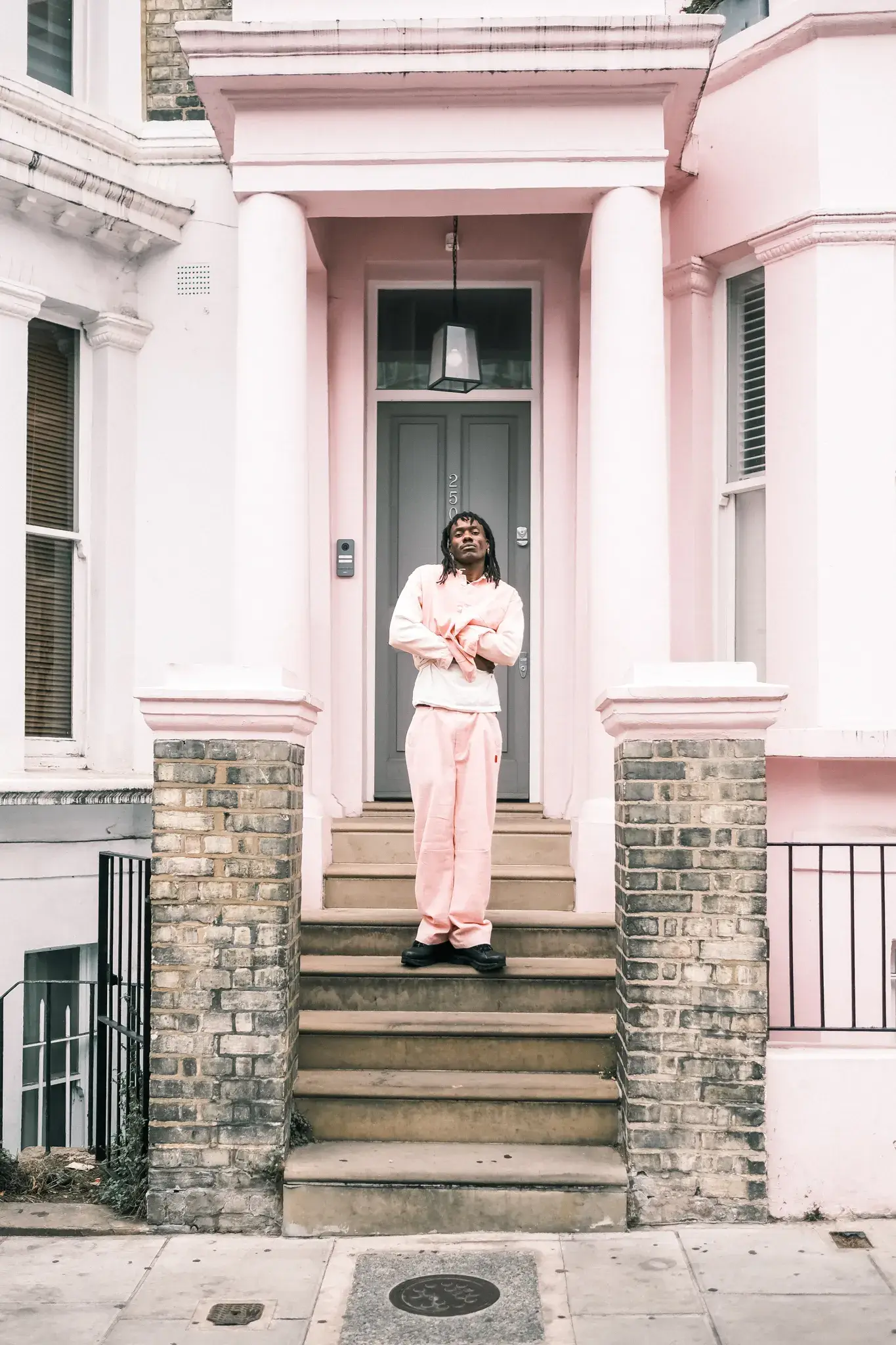GOGO LUPIN: PINK, IDENTITY & CREATIVE FREEDOM image of multidisciplinary artist Gogo Lupin posing in a pink-accented outfit during a portrait session for his Casawi interview. (image 3 of 6)