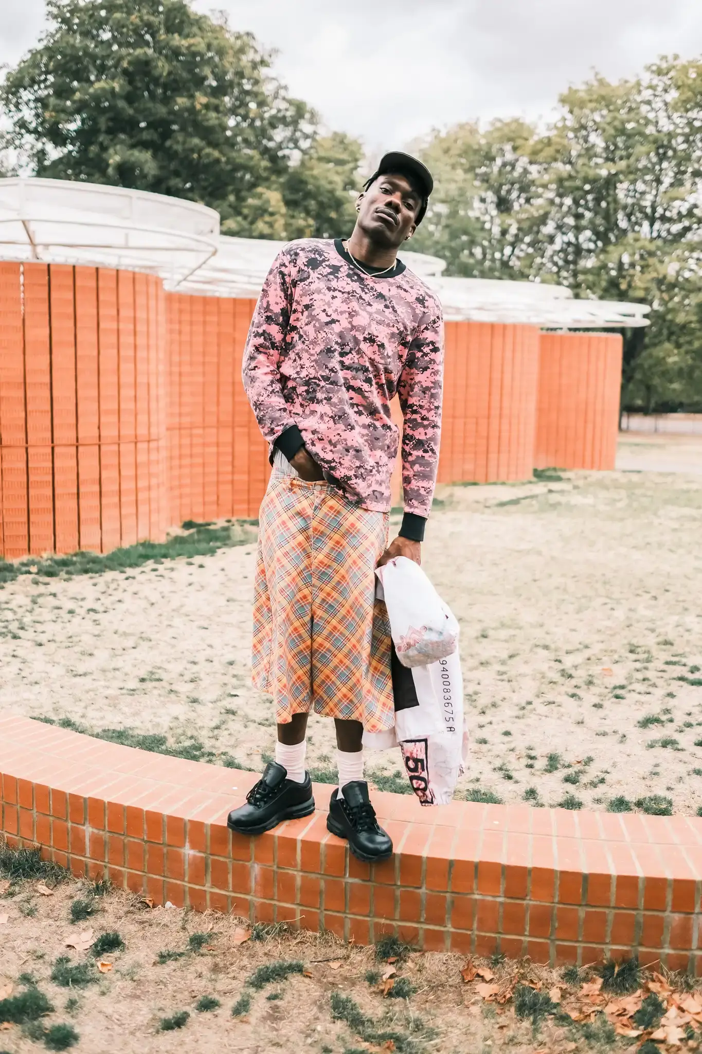 GOGO LUPIN: PINK, IDENTITY & CREATIVE FREEDOM image of multidisciplinary artist Gogo Lupin posing in a pink-accented outfit during a portrait session for his Casawi interview. (image 6 of 6)