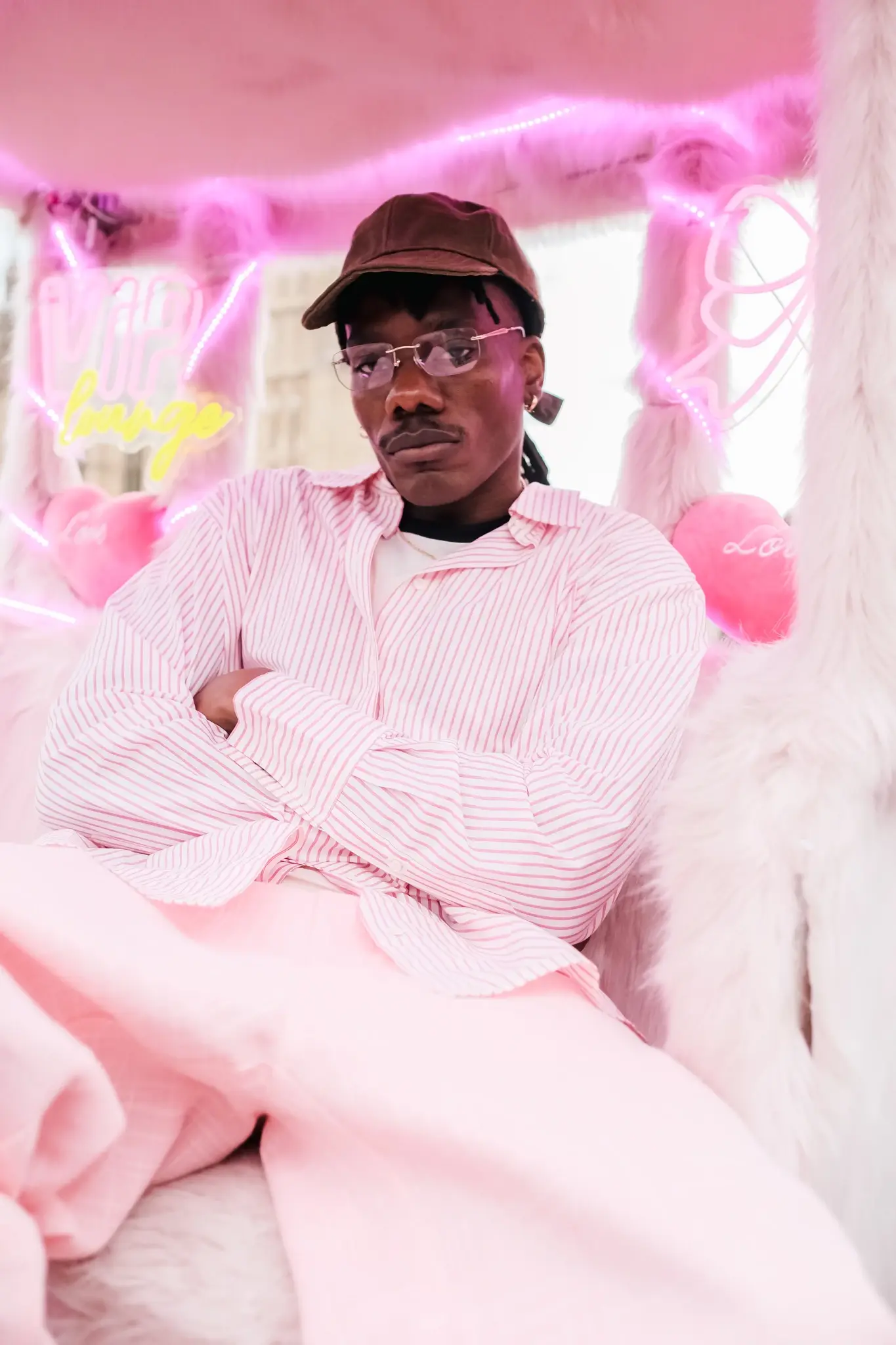 GOGO LUPIN: PINK, IDENTITY & CREATIVE FREEDOM image of multidisciplinary artist Gogo Lupin posing in a pink-accented outfit during a portrait session for his Casawi interview. (image 2 of 6)