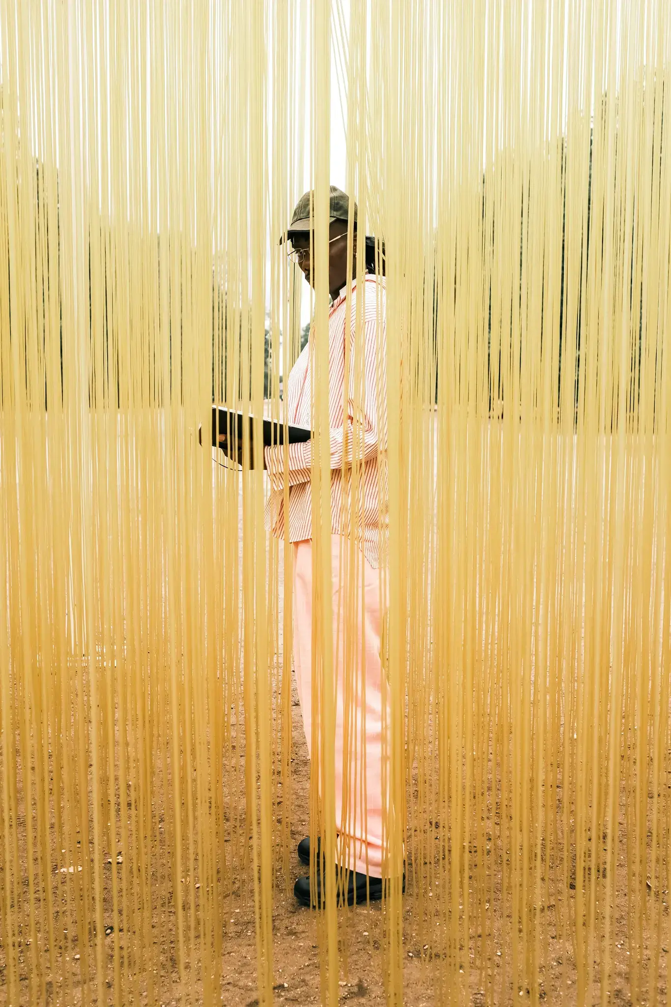 image of multidisciplinary artist Gogo Lupin posing in a pink-accented outfit during a portrait session for his Casawi interview.