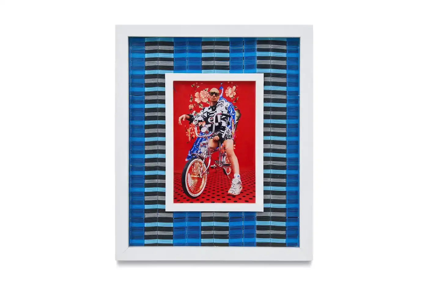 Courtesy Of The Artist And Hannah Traore Gallery Portrait gallery wall showing Hassan Hajjaj's photographs in colorful recycled Moroccan floor mat frames. Models wear mixed pattern clothing against vibrant backgrounds. (image 2 of 7)