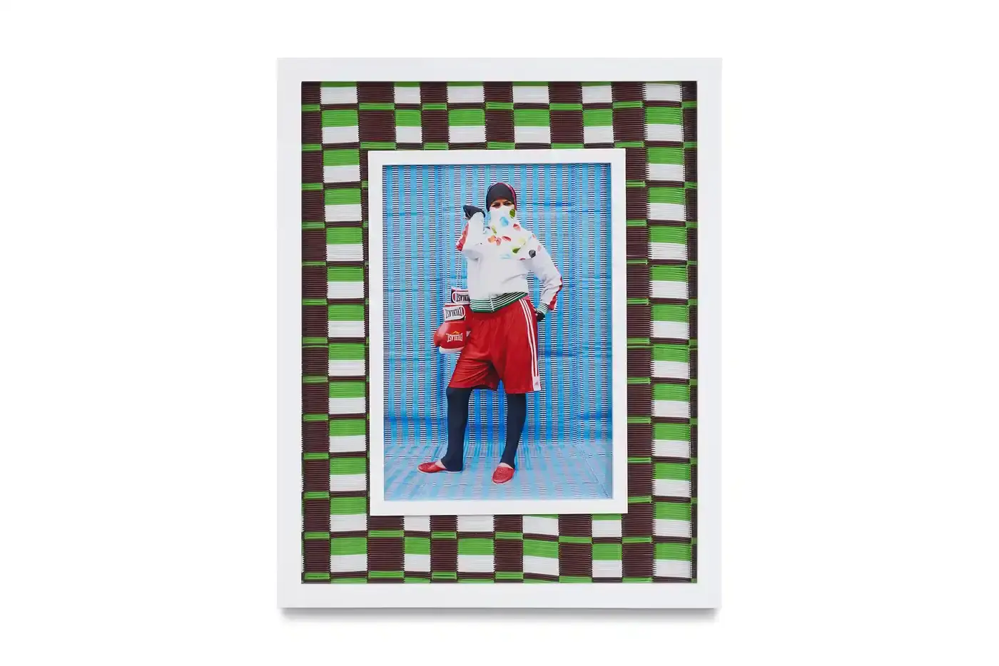 Courtesy Of The Artist And Hannah Traore Gallery Portrait gallery wall showing Hassan Hajjaj's photographs in colorful recycled Moroccan floor mat frames. Models wear mixed pattern clothing against vibrant backgrounds. (image 6 of 7)
