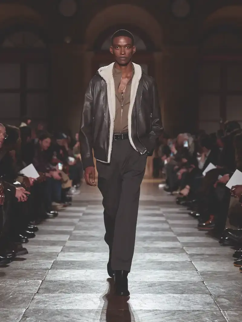 HERMÈS MENSWEAR FW26 COLLECTION Article about Hermès Fall Winter 2026 menswear collection designed by Véronique Nichanian. The collection emphasizes clean construction, quality fabrics, and interior garment finishing. Color palette ranges from hemp and lichen to saffron and midnight blue. The design philosophy focuses on timeless pieces and precise craftsmanship. (image 7 of 58)
