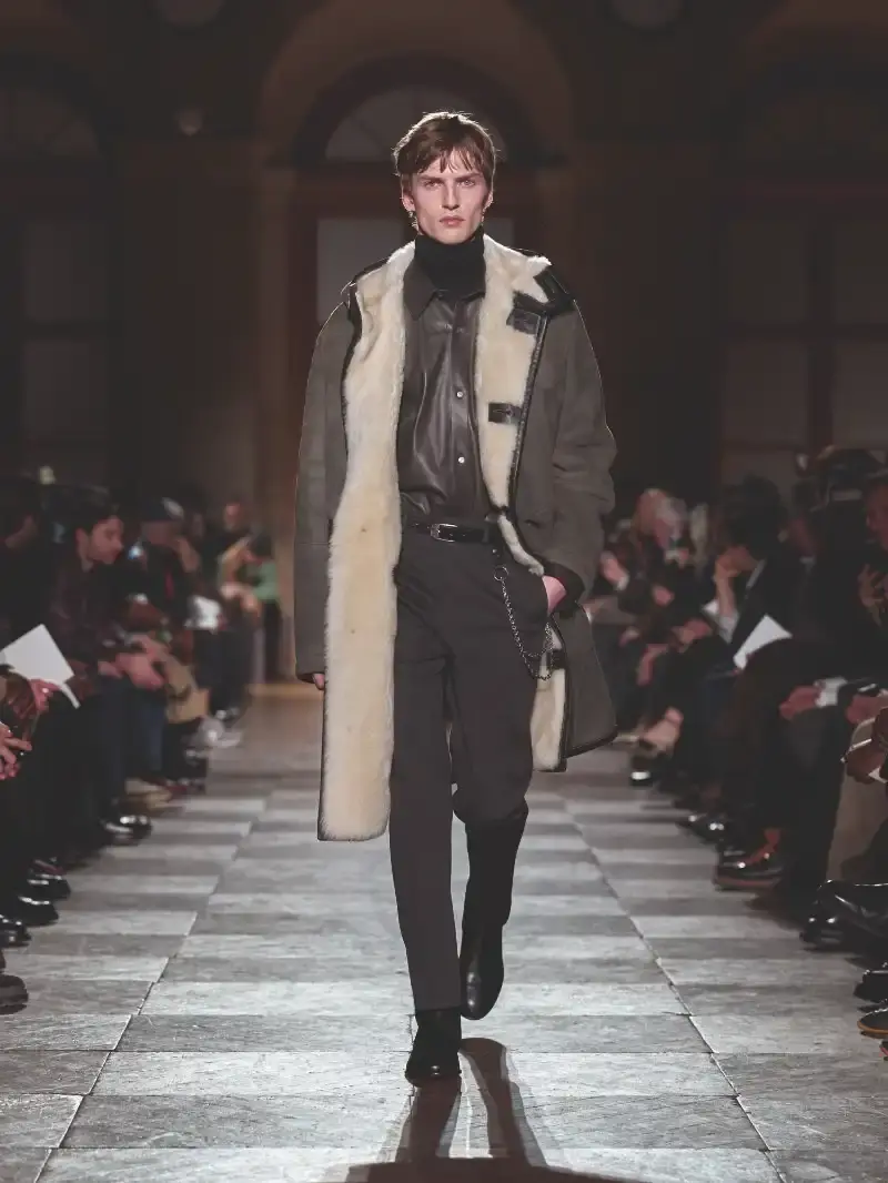 HERMÈS MENSWEAR FW26 COLLECTION Article about Hermès Fall Winter 2026 menswear collection designed by Véronique Nichanian. The collection emphasizes clean construction, quality fabrics, and interior garment finishing. Color palette ranges from hemp and lichen to saffron and midnight blue. The design philosophy focuses on timeless pieces and precise craftsmanship. (image 8 of 58)