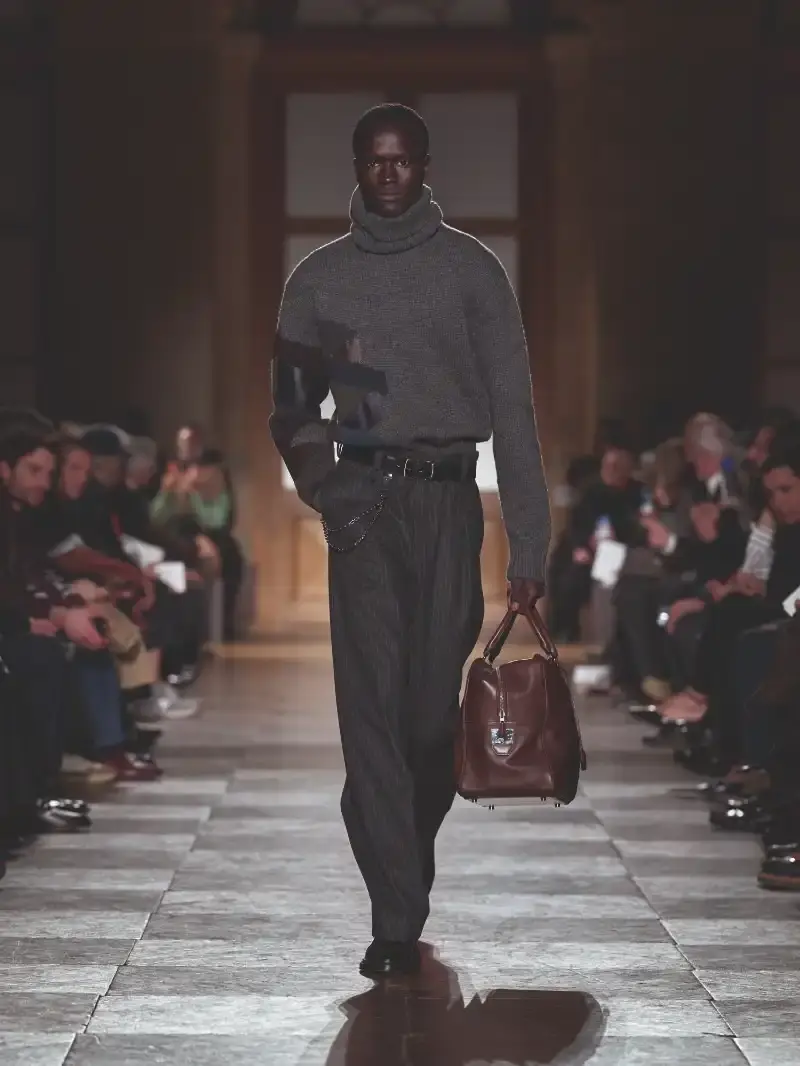 HERMÈS MENSWEAR FW26 COLLECTION Article about Hermès Fall Winter 2026 menswear collection designed by Véronique Nichanian. The collection emphasizes clean construction, quality fabrics, and interior garment finishing. Color palette ranges from hemp and lichen to saffron and midnight blue. The design philosophy focuses on timeless pieces and precise craftsmanship. (image 28 of 58)