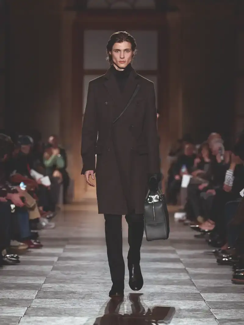 HERMÈS MENSWEAR FW26 COLLECTION Article about Hermès Fall Winter 2026 menswear collection designed by Véronique Nichanian. The collection emphasizes clean construction, quality fabrics, and interior garment finishing. Color palette ranges from hemp and lichen to saffron and midnight blue. The design philosophy focuses on timeless pieces and precise craftsmanship. (image 33 of 58)