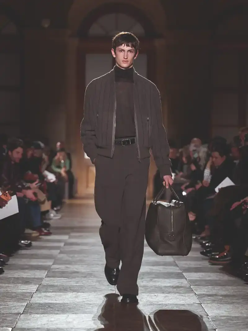 HERMÈS MENSWEAR FW26 COLLECTION Article about Hermès Fall Winter 2026 menswear collection designed by Véronique Nichanian. The collection emphasizes clean construction, quality fabrics, and interior garment finishing. Color palette ranges from hemp and lichen to saffron and midnight blue. The design philosophy focuses on timeless pieces and precise craftsmanship. (image 24 of 58)