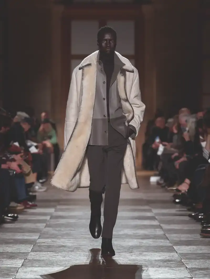 HERMÈS MENSWEAR FW26 COLLECTION Article about Hermès Fall Winter 2026 menswear collection designed by Véronique Nichanian. The collection emphasizes clean construction, quality fabrics, and interior garment finishing. Color palette ranges from hemp and lichen to saffron and midnight blue. The design philosophy focuses on timeless pieces and precise craftsmanship. (image 16 of 58)