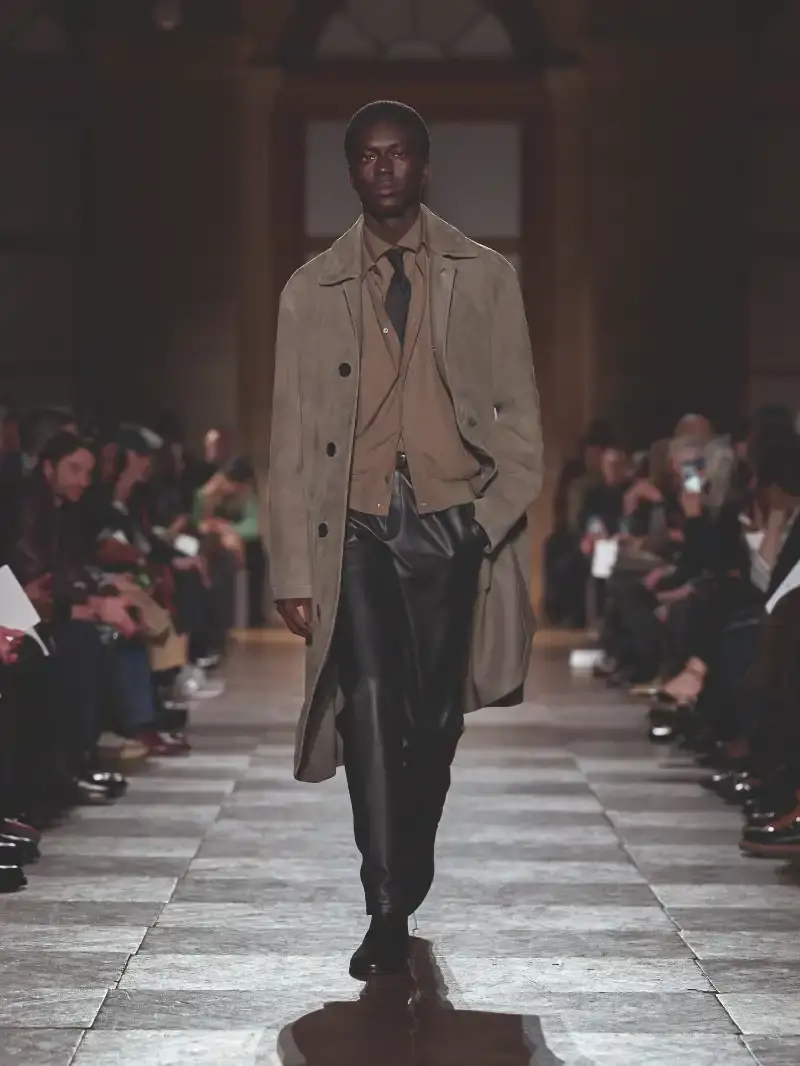 HERMÈS MENSWEAR FW26 COLLECTION Article about Hermès Fall Winter 2026 menswear collection designed by Véronique Nichanian. The collection emphasizes clean construction, quality fabrics, and interior garment finishing. Color palette ranges from hemp and lichen to saffron and midnight blue. The design philosophy focuses on timeless pieces and precise craftsmanship. (image 14 of 58)