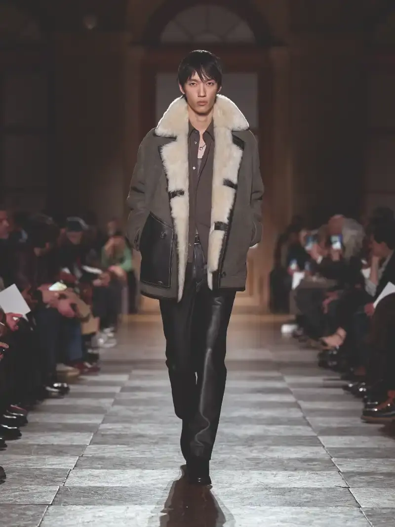 HERMÈS MENSWEAR FW26 COLLECTION Article about Hermès Fall Winter 2026 menswear collection designed by Véronique Nichanian. The collection emphasizes clean construction, quality fabrics, and interior garment finishing. Color palette ranges from hemp and lichen to saffron and midnight blue. The design philosophy focuses on timeless pieces and precise craftsmanship. (image 13 of 58)