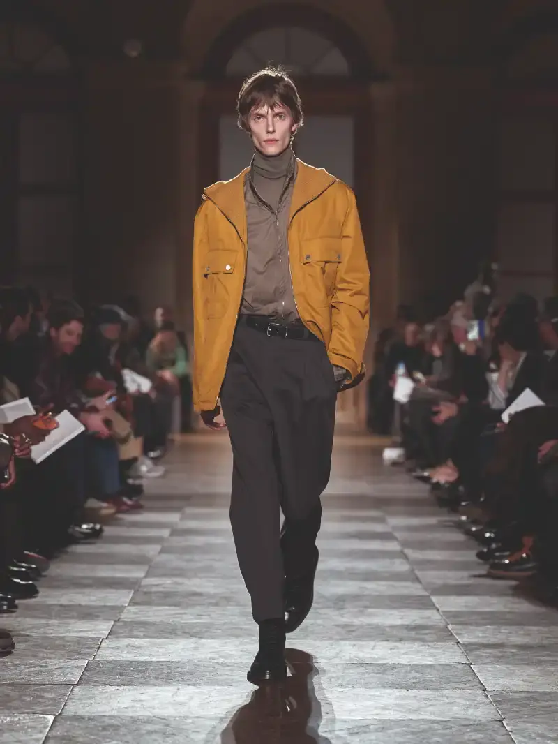 HERMÈS MENSWEAR FW26 COLLECTION Article about Hermès Fall Winter 2026 menswear collection designed by Véronique Nichanian. The collection emphasizes clean construction, quality fabrics, and interior garment finishing. Color palette ranges from hemp and lichen to saffron and midnight blue. The design philosophy focuses on timeless pieces and precise craftsmanship. (image 20 of 58)