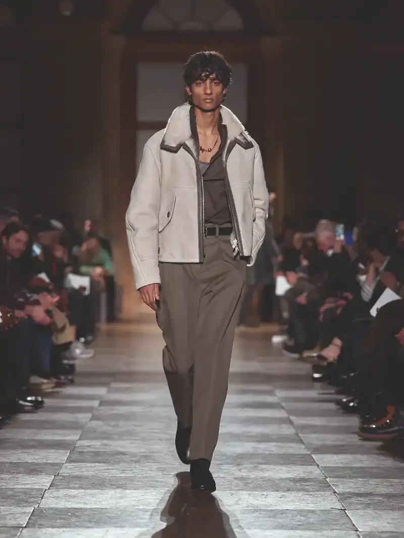 HERMÈS MENSWEAR FW26 COLLECTION Article about Hermès Fall Winter 2026 menswear collection designed by Véronique Nichanian. The collection emphasizes clean construction, quality fabrics, and interior garment finishing. Color palette ranges from hemp and lichen to saffron and midnight blue. The design philosophy focuses on timeless pieces and precise craftsmanship. (image 5 of 58)