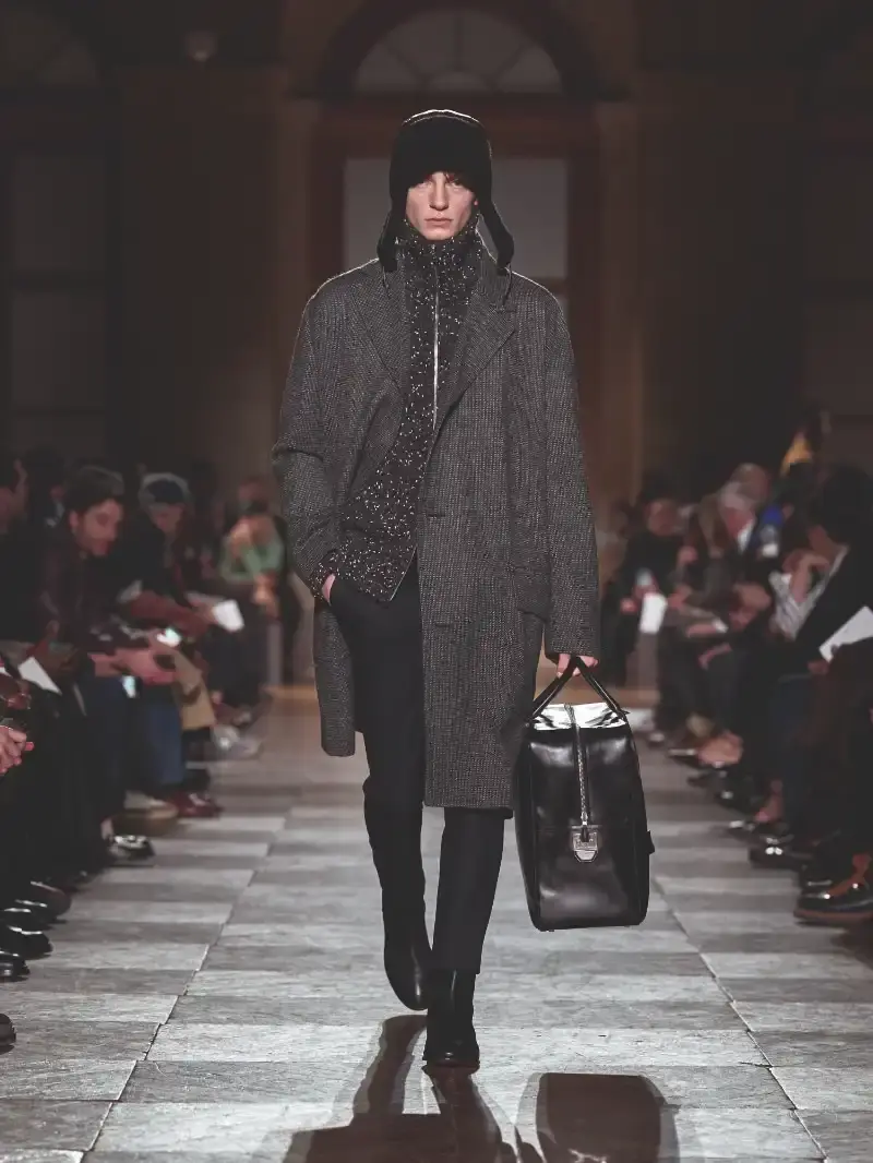 HERMÈS MENSWEAR FW26 COLLECTION Article about Hermès Fall Winter 2026 menswear collection designed by Véronique Nichanian. The collection emphasizes clean construction, quality fabrics, and interior garment finishing. Color palette ranges from hemp and lichen to saffron and midnight blue. The design philosophy focuses on timeless pieces and precise craftsmanship. (image 35 of 58)