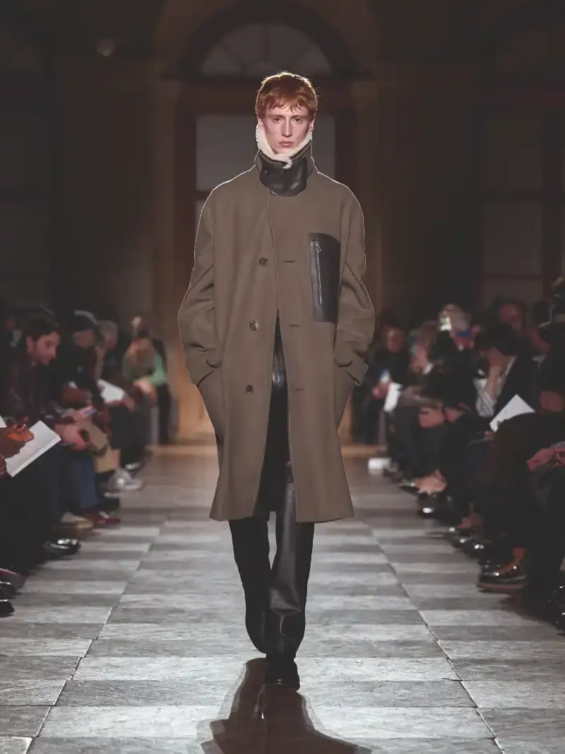 HERMÈS MENSWEAR FW26 COLLECTION Article about Hermès Fall Winter 2026 menswear collection designed by Véronique Nichanian. The collection emphasizes clean construction, quality fabrics, and interior garment finishing. Color palette ranges from hemp and lichen to saffron and midnight blue. The design philosophy focuses on timeless pieces and precise craftsmanship. (image 19 of 58)