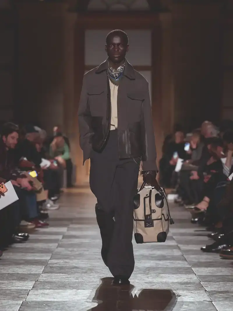 HERMÈS MENSWEAR FW26 COLLECTION Article about Hermès Fall Winter 2026 menswear collection designed by Véronique Nichanian. The collection emphasizes clean construction, quality fabrics, and interior garment finishing. Color palette ranges from hemp and lichen to saffron and midnight blue. The design philosophy focuses on timeless pieces and precise craftsmanship. (image 18 of 58)