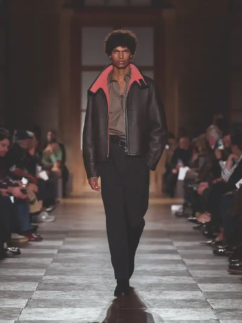 HERMÈS MENSWEAR FW26 COLLECTION Article about Hermès Fall Winter 2026 menswear collection designed by Véronique Nichanian. The collection emphasizes clean construction, quality fabrics, and interior garment finishing. Color palette ranges from hemp and lichen to saffron and midnight blue. The design philosophy focuses on timeless pieces and precise craftsmanship. (image 38 of 58)