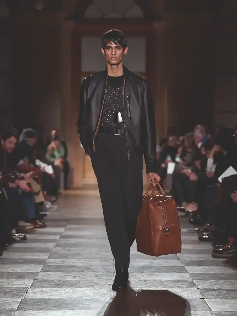 HERMÈS MENSWEAR FW26 COLLECTION Article about Hermès Fall Winter 2026 menswear collection designed by Véronique Nichanian. The collection emphasizes clean construction, quality fabrics, and interior garment finishing. Color palette ranges from hemp and lichen to saffron and midnight blue. The design philosophy focuses on timeless pieces and precise craftsmanship. (image 31 of 58)