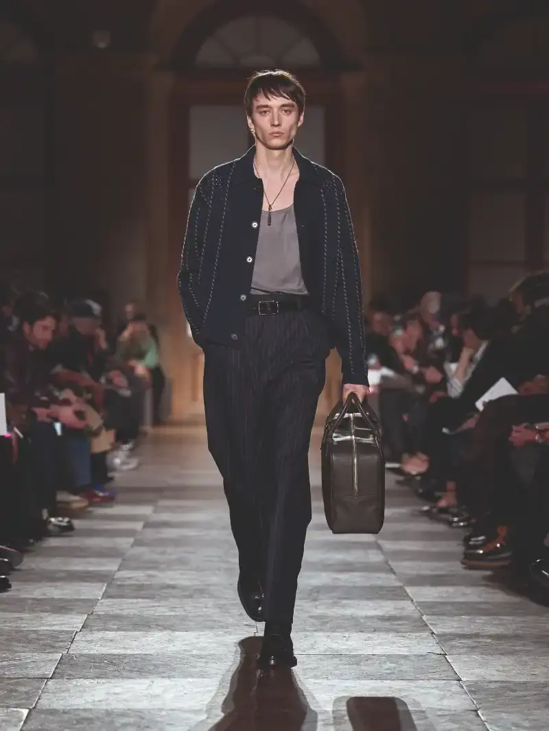 HERMÈS MENSWEAR FW26 COLLECTION Article about Hermès Fall Winter 2026 menswear collection designed by Véronique Nichanian. The collection emphasizes clean construction, quality fabrics, and interior garment finishing. Color palette ranges from hemp and lichen to saffron and midnight blue. The design philosophy focuses on timeless pieces and precise craftsmanship. (image 42 of 58)