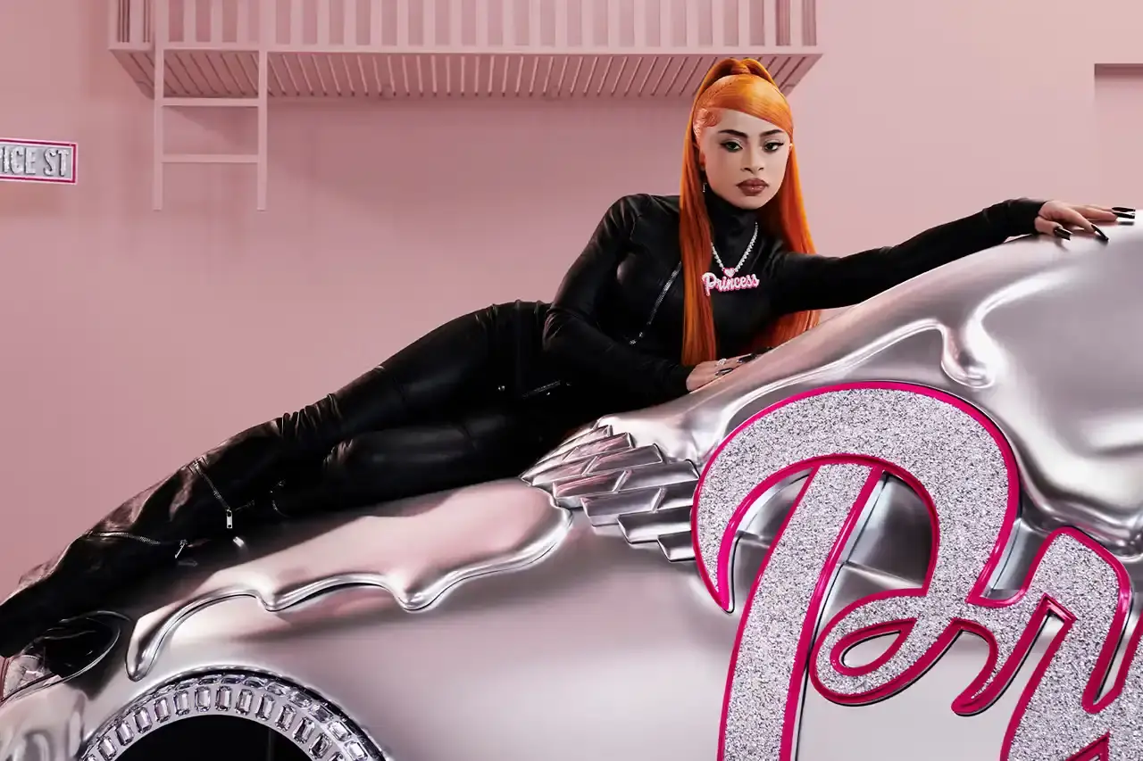CLA GETS ROYAL CHROME TREATMENT IN ICE SPICE'S MERCEDES COLLAB image of rapper Ice Spice's custom collaboration with Mercedes-Benz, featuring a chrome-finished CLA model with princess-themed detailing. It explains that this is part of Mercedes' "Class of Creators" initiative, where five artists will create custom interpretations of the CLA. The piece details the unveiling event at Mercedes' New York dealership, which included performances from Broadway's "Hell's Kitchen" cast and music by DJ LPX. The article also mentions Ice Spice's upcoming merchandise collection and notes that other collaborators will include Gustaf Westman, KidSuper, League of Legends, and Hot Wheels. (image 3 of 11)